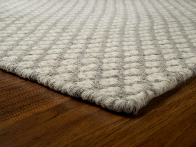 A wool rug on a hardwood floor.